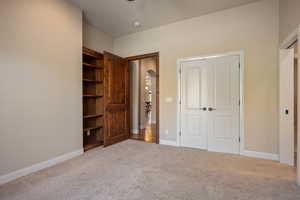 Unfurnished bedroom featuring light colored carpet and a closet