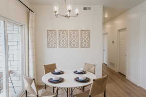 Pics are of model home.Dining space featuring light hardwood / wood-style flooring and an inviting chandelier