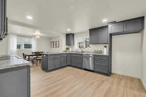 Kitchen with dishwasher, sink, light hardwood / wood-style flooring, gray cabinets, and kitchen peninsula