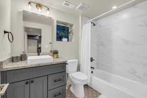 Full bathroom with shower / bath combination with curtain, toilet, and vanity