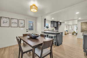 Dining area with light wood-type flooring and sink