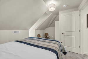 Carpeted bedroom with lofted ceiling