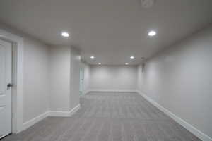 Basement featuring light colored carpet