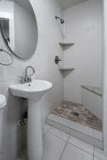 Bathroom featuring a shower, tile patterned flooring, sink, and toilet