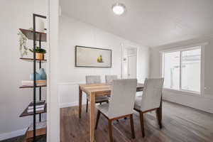 Dining room with hardwood / wood-style floors, crown molding, and lofted ceiling