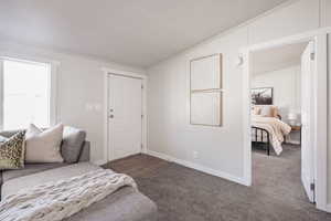 Carpeted bedroom with a textured ceiling, vaulted ceiling, and crown molding