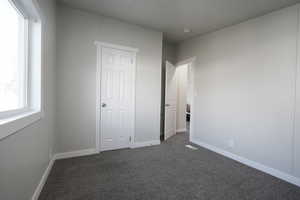 Unfurnished bedroom featuring dark colored carpet