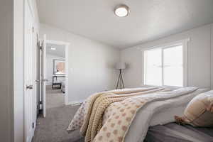 Carpeted bedroom featuring a textured ceiling and lofted ceiling