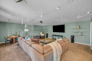 Living room with ceiling fan and a textured ceiling