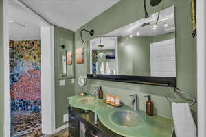 Bathroom featuring vanity, a shower, and a textured ceiling