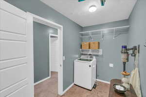 Laundry area featuring washer / dryer and a textured ceiling