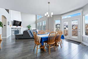 Dining room with dark hardwood / wood-style floors, a wealth of natural light, and a chandelier