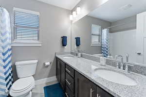 Bathroom with tile patterned floors, vanity, and toilet