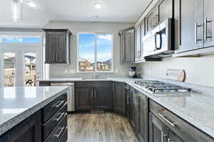 Kitchen featuring light stone countertops, appliances with stainless steel finishes, plenty of natural light, and sink