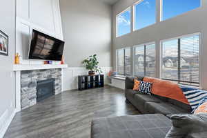 Living room with a stone fireplace and dark hardwood / wood-style floors