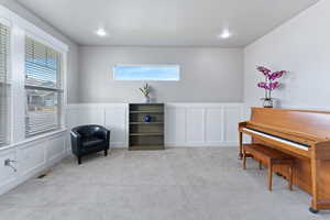 Living area featuring light colored carpet and a healthy amount of sunlight