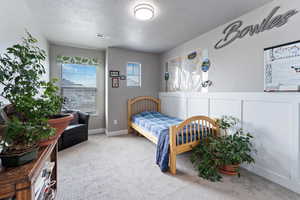 Bedroom with carpet flooring and a textured ceiling