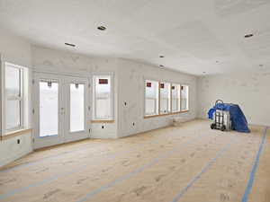 Interior space with french doors and a textured ceiling