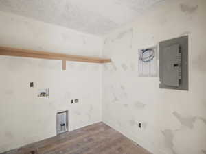 Washroom featuring washer hookup, wood-type flooring, and electric panel