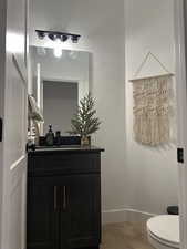 Bathroom featuring hardwood / wood-style floors, vanity, and toilet