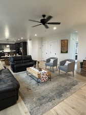 Living room with ceiling fan and light hardwood / wood-style floors