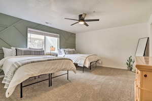 Bedroom with a textured ceiling, carpet floors, and ceiling fan