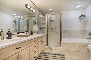 Full bathroom with separate shower and tub, tile patterned floors, vanity, and toilet