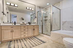 Full bathroom featuring tile patterned flooring, vanity, toilet, and shower with separate bathtub