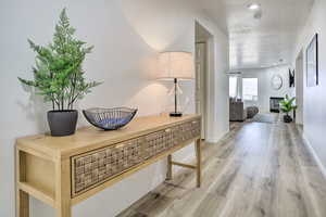 Hall featuring a textured ceiling and hardwood / wood-style flooring