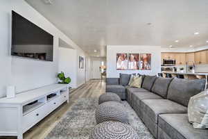 Living room featuring light hardwood / wood-style floors and a textured ceiling