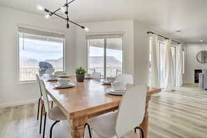 Dining space with a mountain view, plenty of natural light, light wood-type flooring, and a fireplace