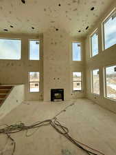 Unfurnished living room featuring plenty of natural light and a high ceilingPhoto taken 1/31/25