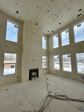 Unfurnished living room featuring a high ceiling and a wealth of natural light Photo taken 1/31/25