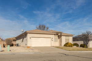 View of front of house with central air condition unit and a garage