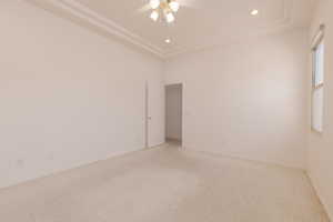 Carpeted spare room with ceiling fan and a tray ceiling