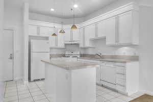 Kitchen with a center island, light tile patterned floors, pendant lighting, white appliances, and white cabinets