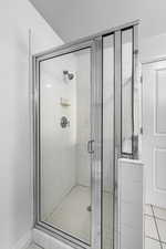 Bathroom featuring tile patterned floors and a shower with door