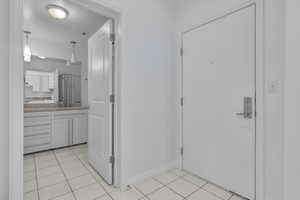 Interior space featuring sink and light tile patterned flooring