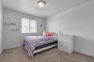 Bedroom featuring light carpet