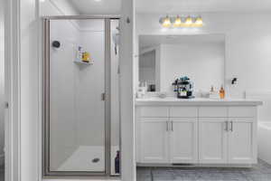 Bathroom featuring vanity and independent shower and bath