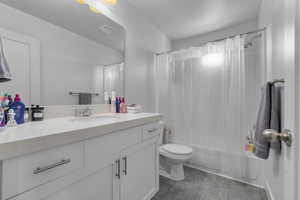 Full bathroom featuring tile patterned floors, vanity, shower / bathtub combination with curtain, and toilet