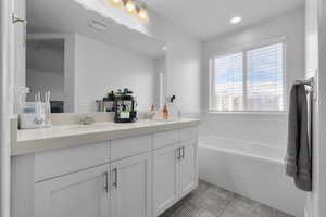 Bathroom with tile patterned flooring, vanity, and a bathing tub