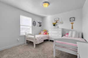 Bedroom with multiple windows and light colored carpet