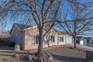 View of front of property with central air condition unit and a garage