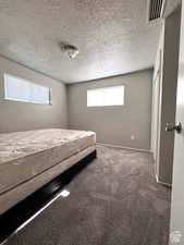 Unfurnished bedroom with carpet and a textured ceiling