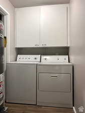 Laundry room featuring cabinets, gas water heater, dark hardwood / wood-style floors, independent washer and dryer, and a textured ceiling