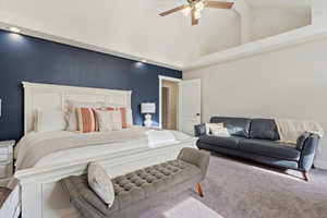 Bedroom with carpet, ceiling fan, and high vaulted ceiling