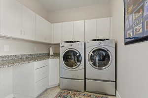 Laundry room with washer and dryer and cabinets