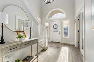 Entryway with a towering ceiling and light wood-type flooring