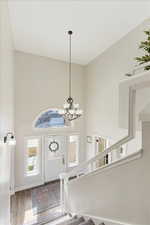 Entrance foyer with an inviting chandelier, a high ceiling, and hardwood / wood-style flooring